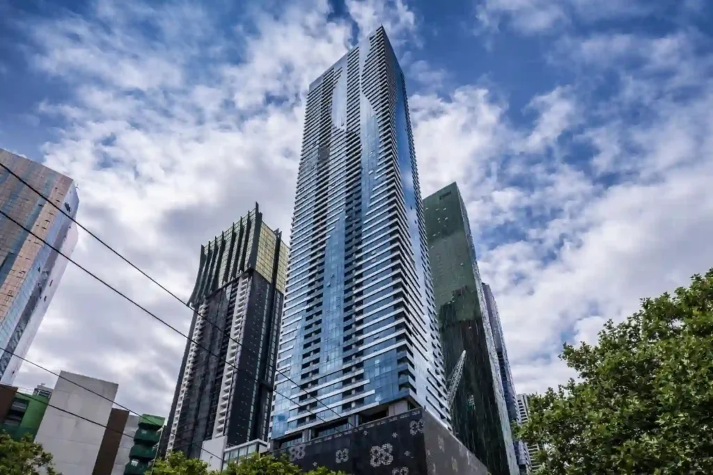 نمای برج Vision Apartments در شمال‌شرق CBD ملبورن با نمای شیشه‌ای آبی از زاویه پایین